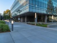 two grey blocks sitting next to a tall building on a sidewalk in front of grass