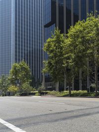 a street scene with an empty intersection and tall buildings in the background, from across the street from an intersection where there is a car driving red traffic light