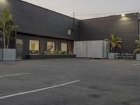 the empty parking lot is decorated with palm trees and other plants on the side of the building