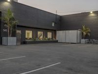 the empty parking lot is decorated with palm trees and other plants on the side of the building