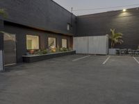 the empty parking lot is decorated with palm trees and other plants on the side of the building