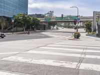 a city street at the intersection of the street and underpass above it is two pedestrian walk signs