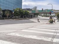 a city street at the intersection of the street and underpass above it is two pedestrian walk signs