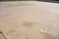 a plane is painted with graffiti on the ground next to barbed wire fenced off airport