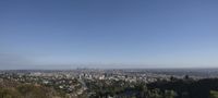 a view of a city from a hill, and to a hill to the right