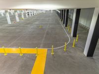 a white parking garage with yellow lines in it that looks like a yellow line to the left