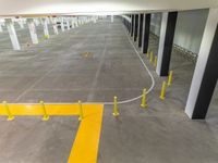 a white parking garage with yellow lines in it that looks like a yellow line to the left