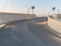 a concrete walkway with a few traffic lights on top of it and signs behind it