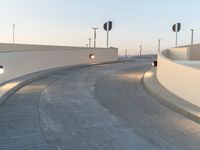 a concrete walkway with a few traffic lights on top of it and signs behind it