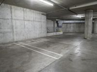 empty concrete parking garage with white lines painted in various directions and light at the end