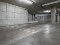 empty concrete parking garage with white lines painted in various directions and light at the end