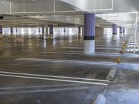 a empty parking garage with concrete flooring and white lines on the ceiling and outside