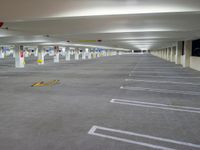 a parking garage with concrete floors and gray carpeting and lighting fixture in front of the car