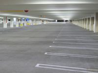 a parking garage with concrete floors and gray carpeting and lighting fixture in front of the car