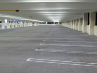 a parking garage with concrete floors and gray carpeting and lighting fixture in front of the car