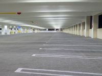 a parking garage with concrete floors and gray carpeting and lighting fixture in front of the car