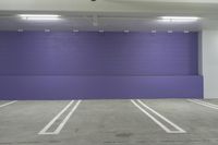 the empty garage has an empty parking space and is blue and purple in color and sizes