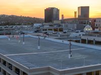 a sky view of a parking lot with parked cars and tall buildings in the background