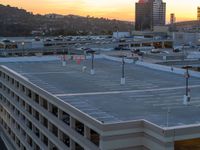 a sky view of a parking lot with parked cars and tall buildings in the background