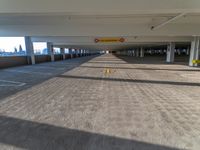 an empty parking garage with two yellow yellow warning signs attached to the ceiling and no people in it