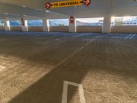 a parking garage with empty parking spaces for cars, parking meters and to universal signs