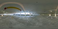 a fisheye lens picture of an empty parking lot with people walking around the parking spots