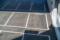 a parking lot with two white and three black lines marked in the asphalt and the word