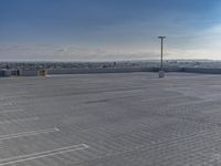 a parking lot that has a few vehicles parked in it with a blue sky above