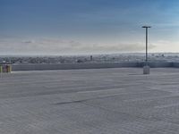 a parking lot that has a few vehicles parked in it with a blue sky above