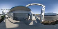 a fish eye lens in an empty parking lot next to a building on a sunny day