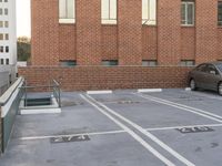 a brick parking lot with a car and stairs in front of it outside of some buildings