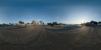 the parking lot has been cracked to reveal an empty area in front of it and a circular mirror of the sky with buildings in back