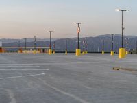 there are several large poles in a parking lot with mountains in the background in the foreground