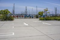 a large parking lot with two white arrows painted in it, next to other boats