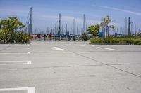 a large parking lot with two white arrows painted in it, next to other boats