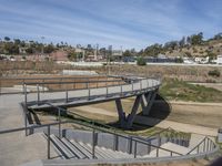 view of a pedestrian bridge crossing over a roadway in a residential area that is not being used for urban transport