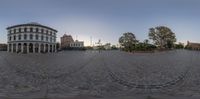 an 360 - image looking up at a plaza with a clock tower in the background