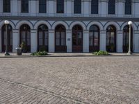 the road outside is a small plaza with two pillars and four archways and an old building with windows