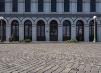 the road outside is a small plaza with two pillars and four archways and an old building with windows