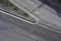 an overhead shot of a street and the sidewalk taken from a top - up view