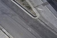 an overhead shot of a street and the sidewalk taken from a top - up view