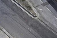 an overhead shot of a street and the sidewalk taken from a top - up view