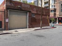 the entrance to the parking garage of an apartment building in a city street with no cars