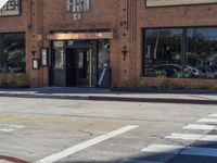 a restaurant sitting on the corner of a street in an intersection with a crosswalk