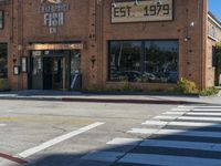 a restaurant sitting on the corner of a street in an intersection with a crosswalk