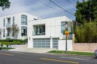 the street view shows a two level, white residential building with multiple garages and attached parking spots