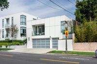 the street view shows a two level, white residential building with multiple garages and attached parking spots