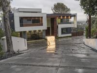 a building with several windows on each of it's sides in the middle of a concrete driveway