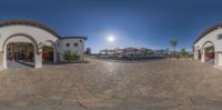 fisheye view of a restaurant at the resort with sun shining over pool area and deck