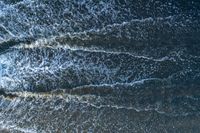 waves are rolling in a shallow pool near a beach at high tide and the sandy shore